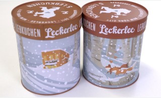 Illustrated Lebkuchen tin featuring a snow-covered Zingerman's deli and foxes in snowy woods.