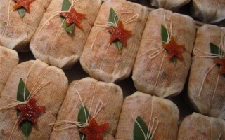 A row of Robert Lambert's fruit cakes wrapped in muslin and tied with twine, with a citrus peel star on top.