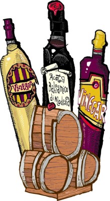 Different bottles of vinegar around vinegar barrels